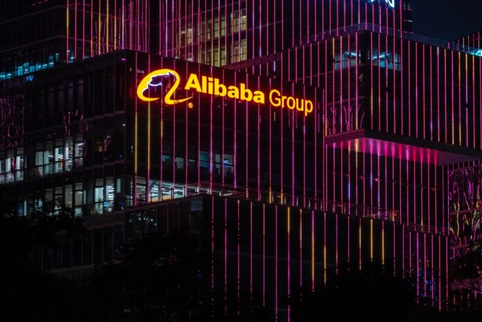 Alibaba Group logo seen on top of a skyscraper at night.